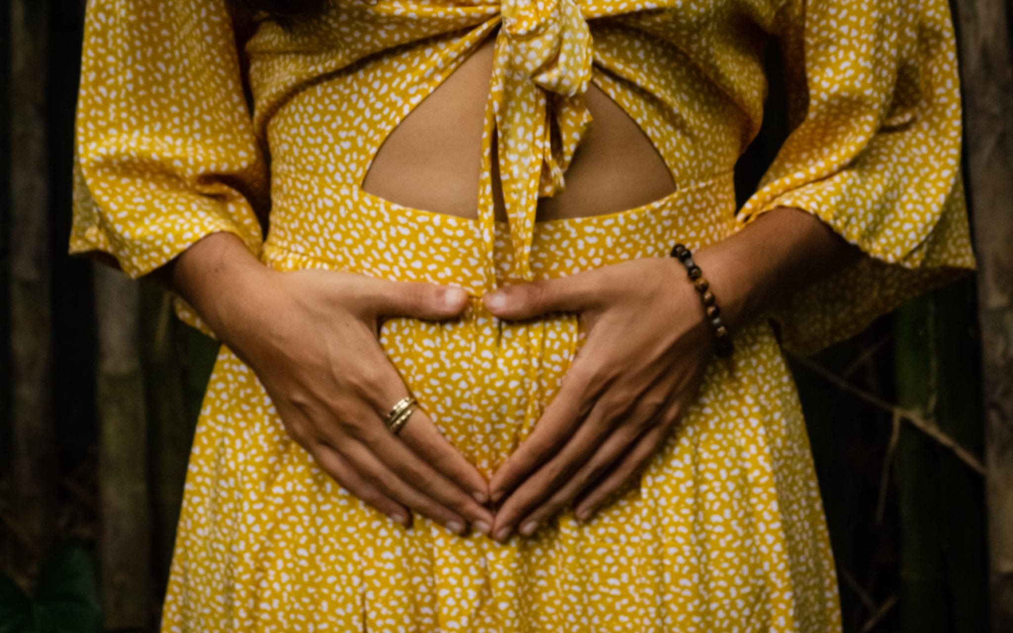 A woman's hand on her womb, expressing her gratitude for her menstrual cycle
