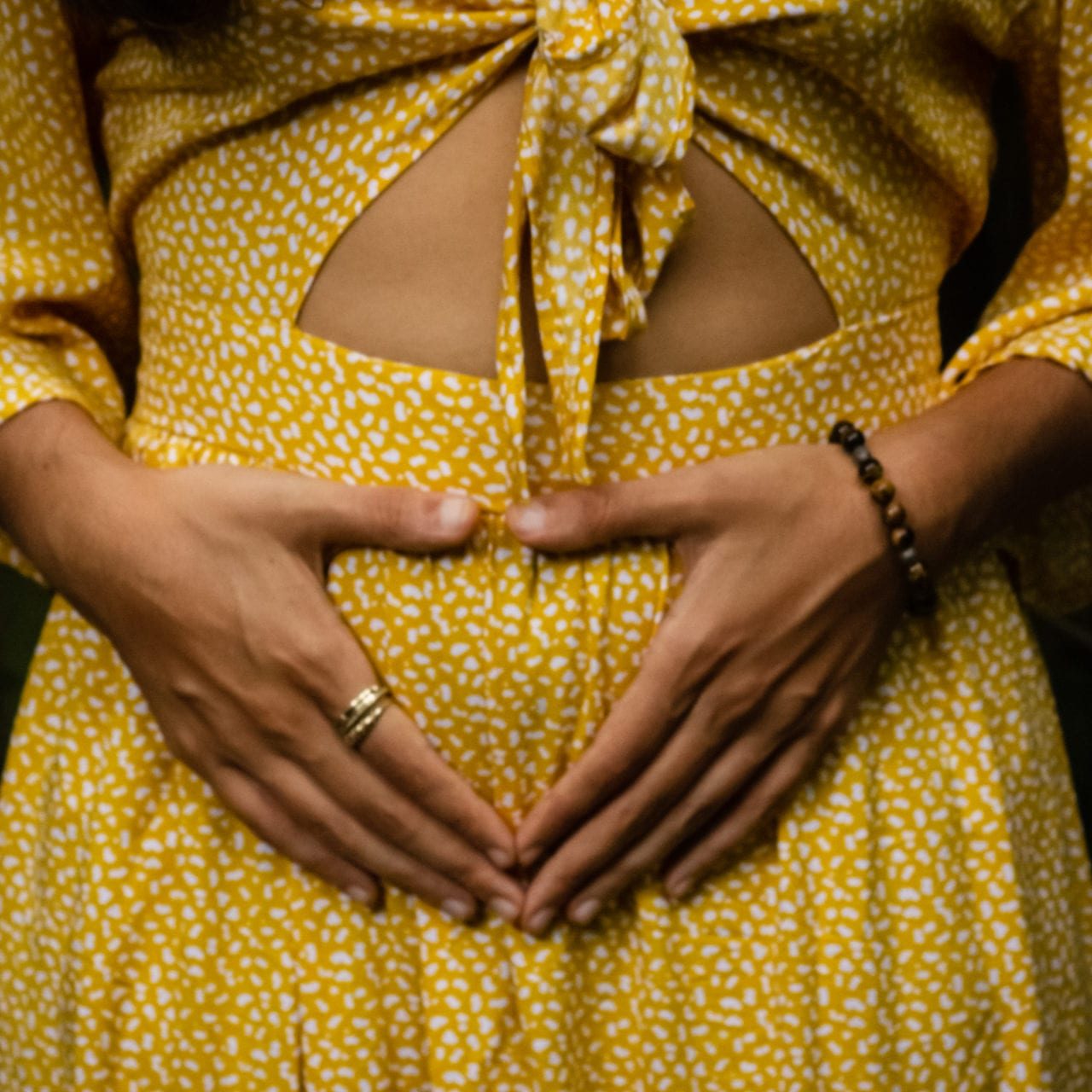 A woman's hand on her womb, expressing her gratitude for her menstrual cycle